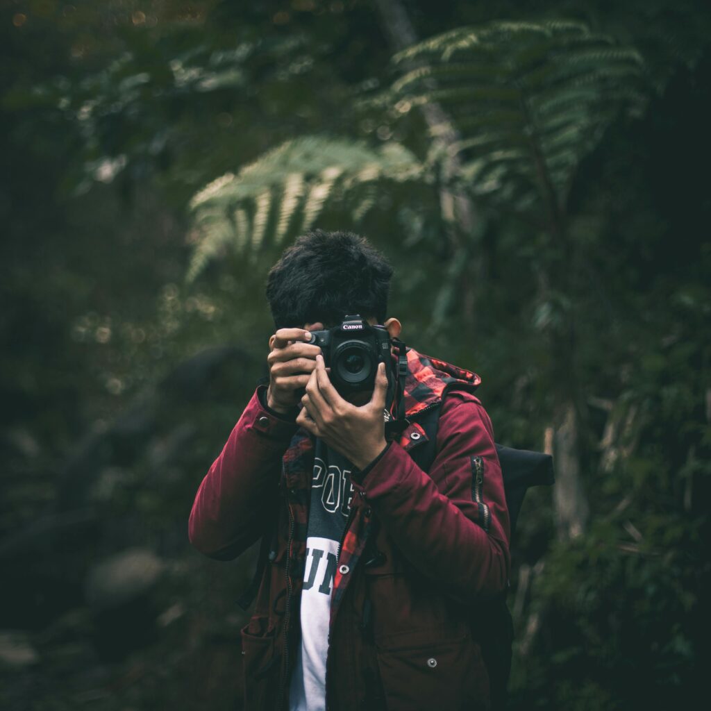 pexels-photo-1567730-1567730 Young man captures nature with DSLR camera in Pamijahan, Indonesia. Explore photography and nature together.