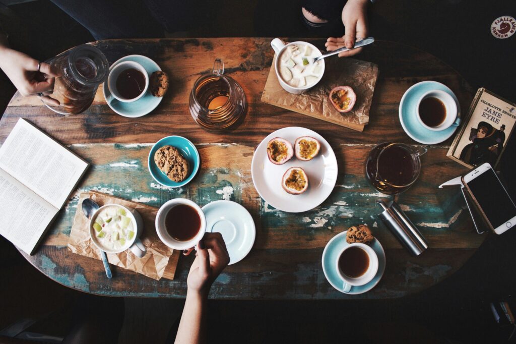pexels-photo-2074130-2074130 Overhead view of a cozy coffee table setup with cups, snacks, and books, perfect for a relaxing afternoon.