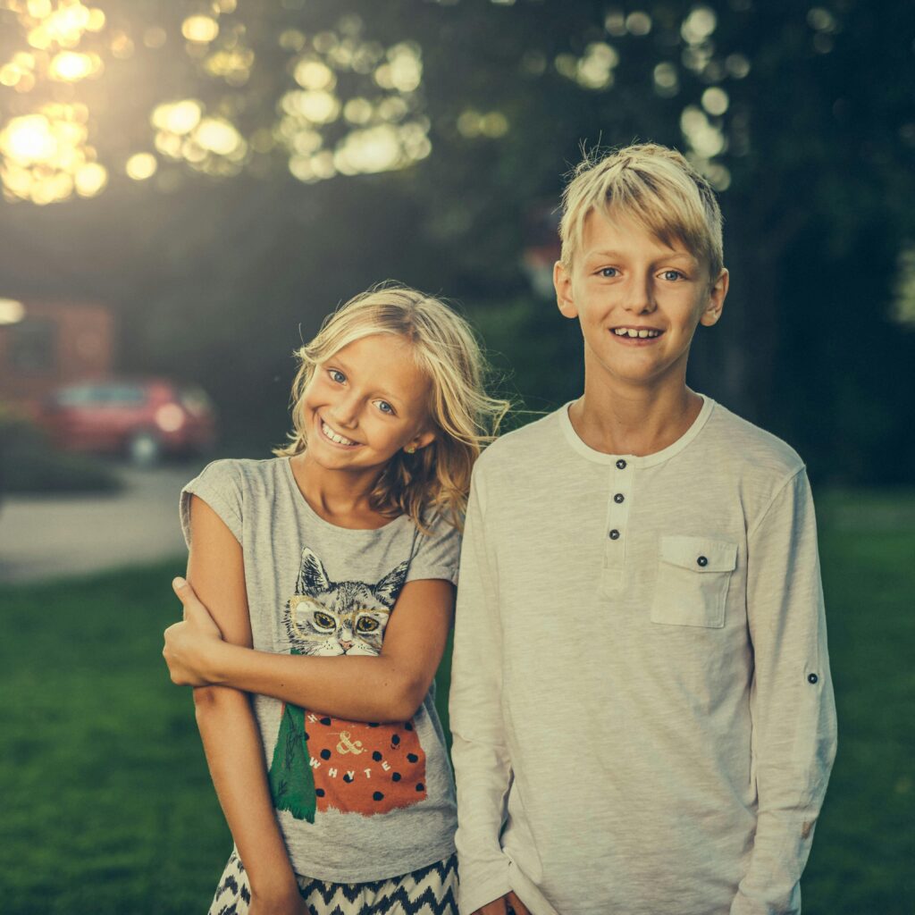 pexels-photo-590472-590472 A joyful brother and sister smiling outdoors in a sunlit garden. Perfect stock photo for family and lifestyle themes.
