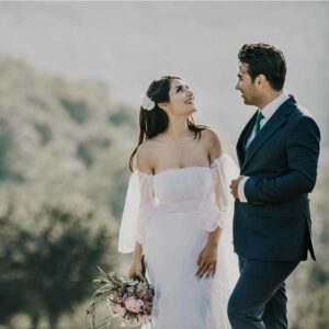 A joyful bride and groom share a loving glance in a beautiful outdoor setting.